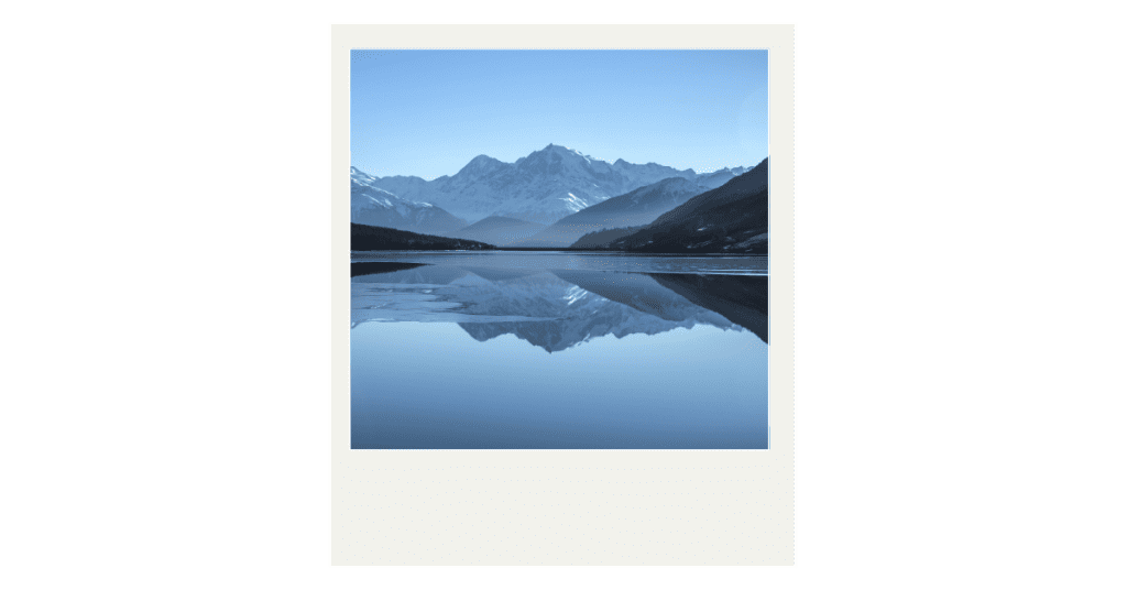 Polaroid of a mountain reflecting on water representing reflection as a reason to write a letter to your future self.